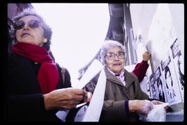 Hilda Saldívar y Doris Meniconi pegando afiches en el frontis de Londres 38, ex centro de detenci...