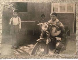 Luis Guajardo en su infancia junto a un niño sobre una motocicleta